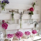 bottles with flowers on a pallet wood summer mantel