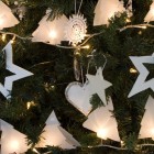 Christmas tree in white with homemade ornaments and lights from paper, wood and fabric