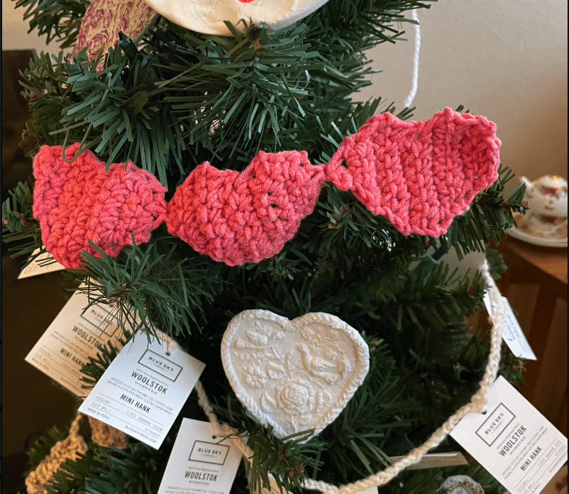 garland with pink crochet hearts on a green christmas tree