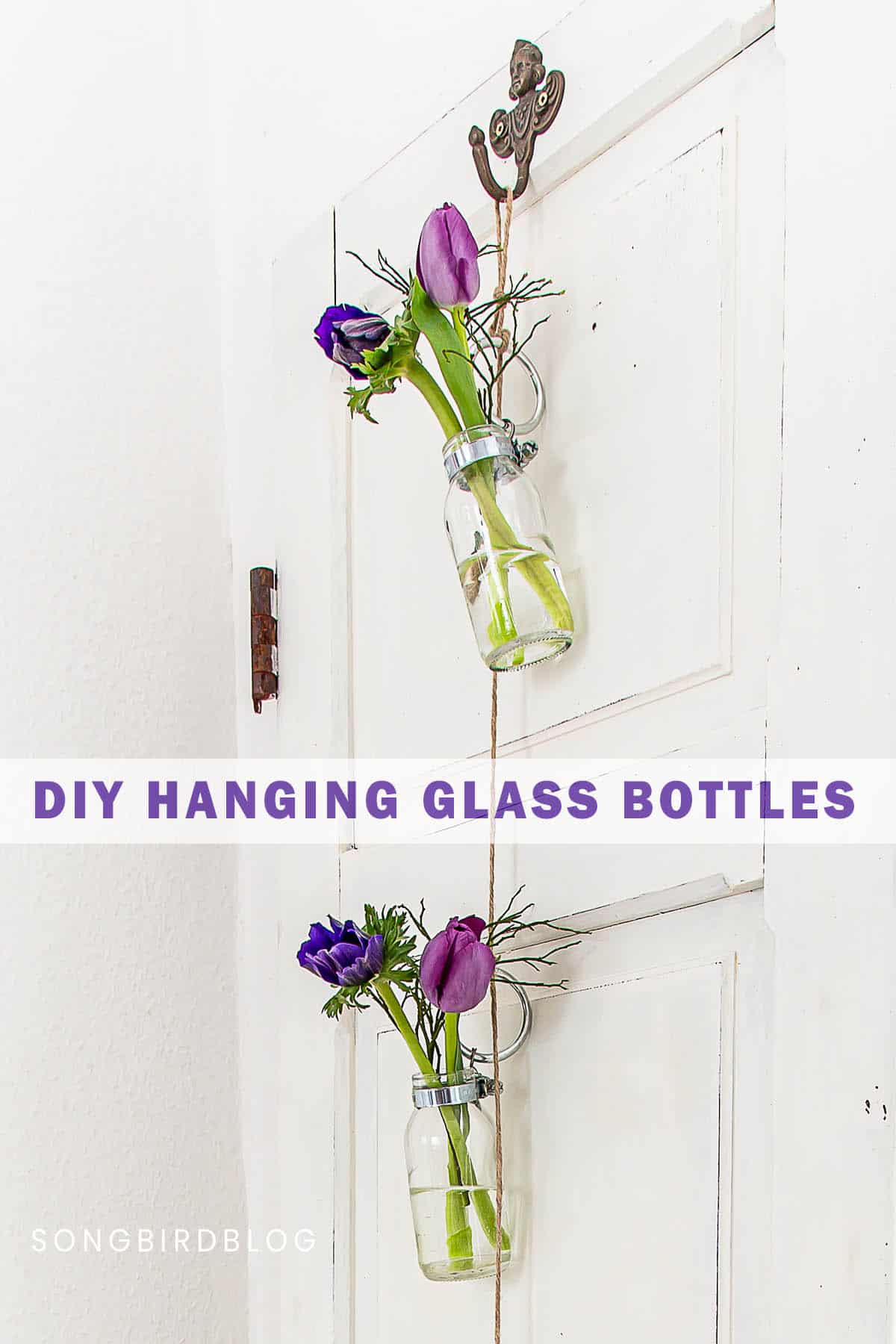 Image of two mini glass bottles with flowers hanging with twine from a hook with overlay DIY hanging glass bottles