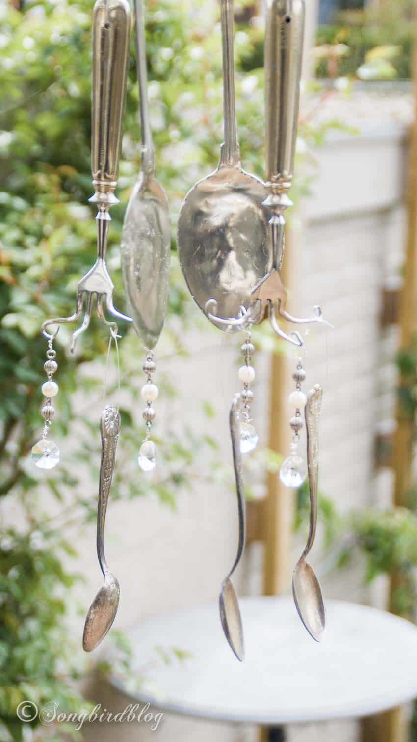 wind chime made from silverware hanging in garden