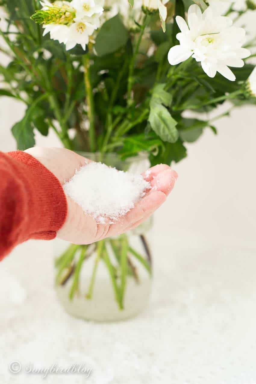 adding faux snow to a winter flower bouquet