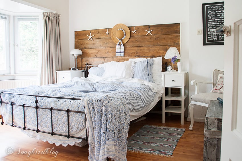 bedroom with blue and white bedding and a wood headboard