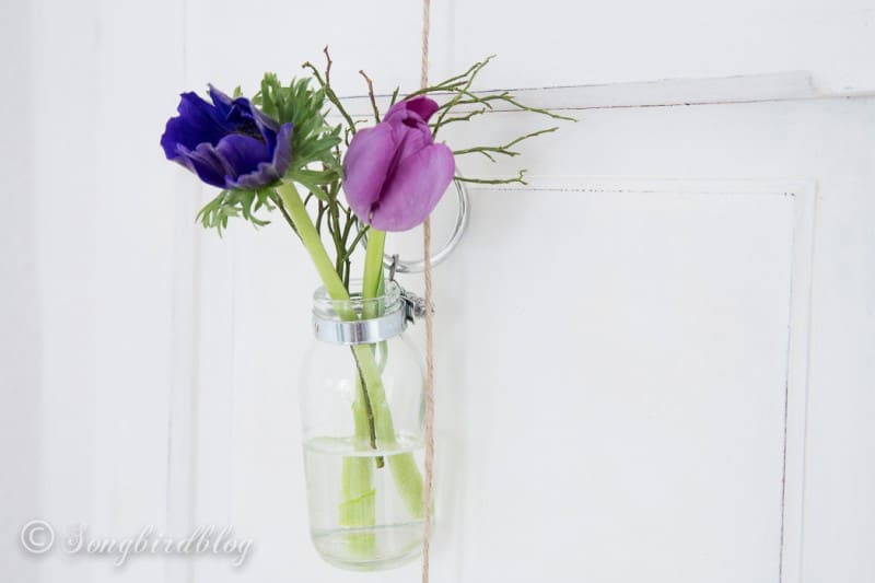 small tulip bouquet in a hanging glass bottle