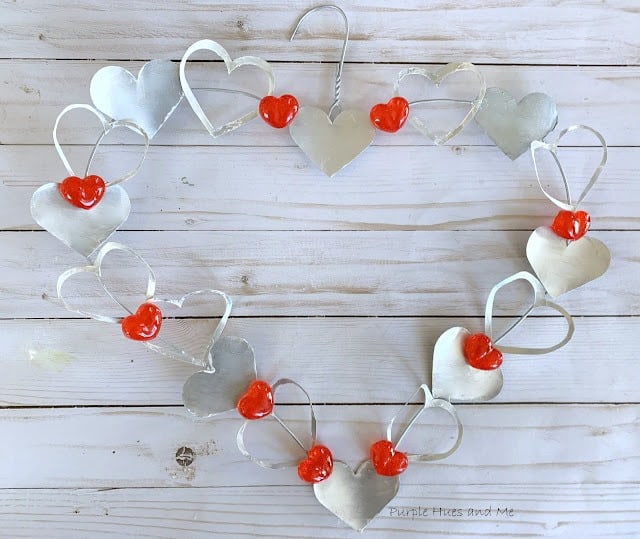 heart shaped wreath made from soda can cutouts in heart shape and a wire hanger