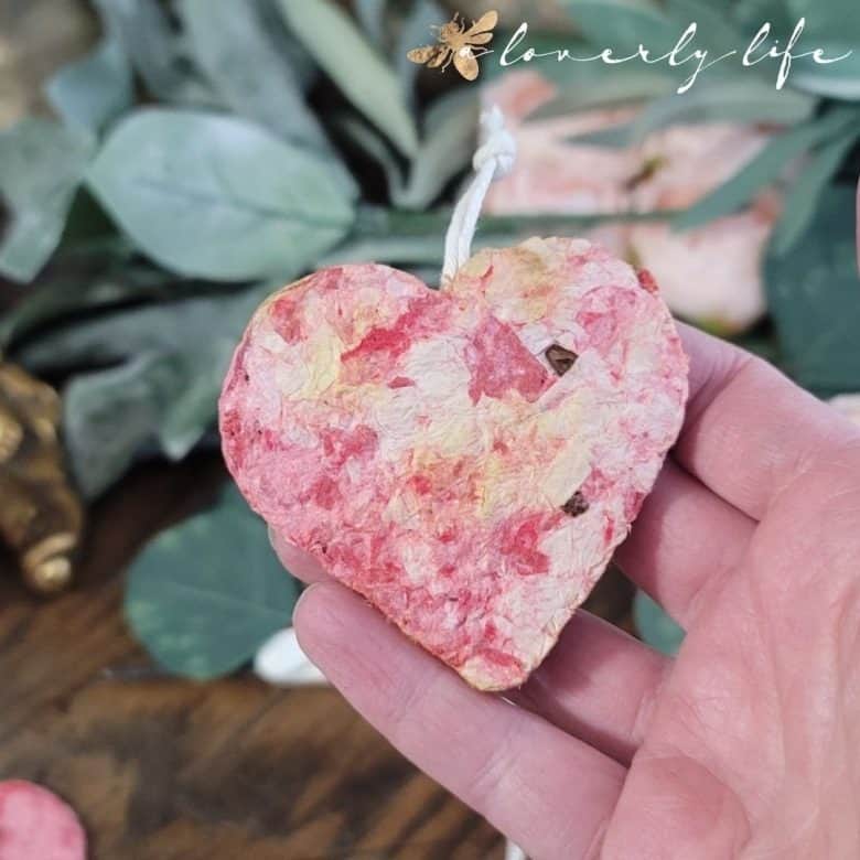Hand showing a recycled paper heart with flower seeds